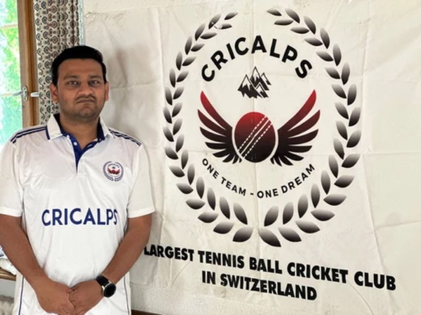 A Cricalps player in the club shirt beside the club banner, which reads "Largest tennis ball cricket club in Switzerland"