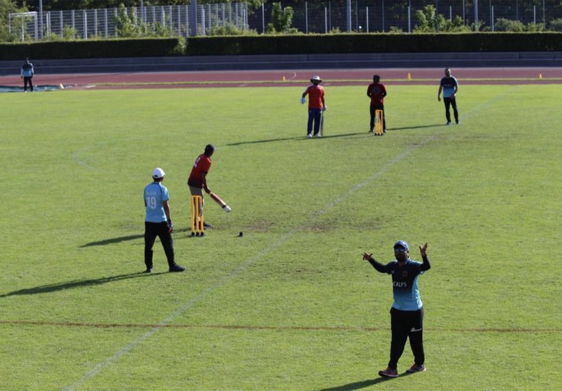 Fielders spread across the ground with the running track and stand behind