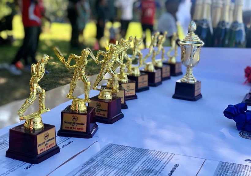A long line of gold trophies waiting on a presentation table